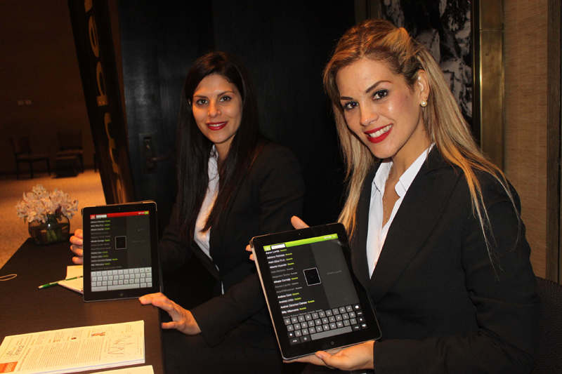 Anfitrionas usando iPads con el sistema de lista de invitados