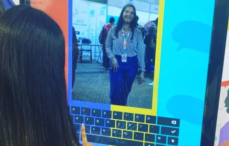 Mujer usando tótem interactivo con selfie y teclado en pantalla