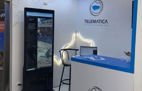 Tótem digital vertical con video en stand corporativo
